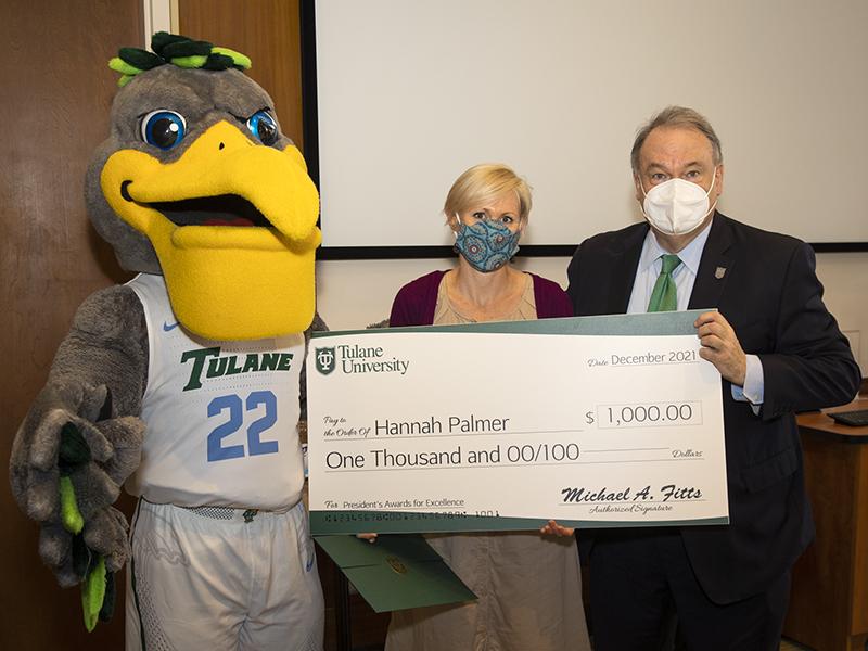 Hannah Palmer, program manager for the Center for Latin American Studies, poses with Riptide and President Fitts with her award.