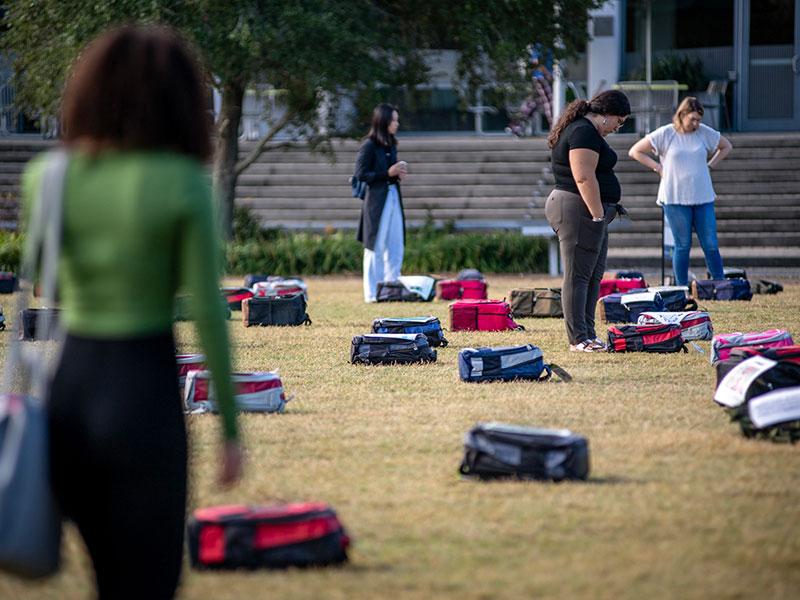 Tulanians perusing backpacks at Send Silence Packing exhibit