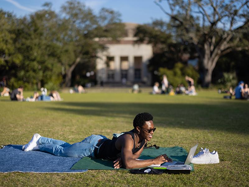 Wilfred Wright, a second year student from New Orleans studying neuroscience, takes advantage of the beautiful weather on the Berger Family Lawn at Tulane University on Wednesday, March 2, 2022 to FaceTime with his mother.