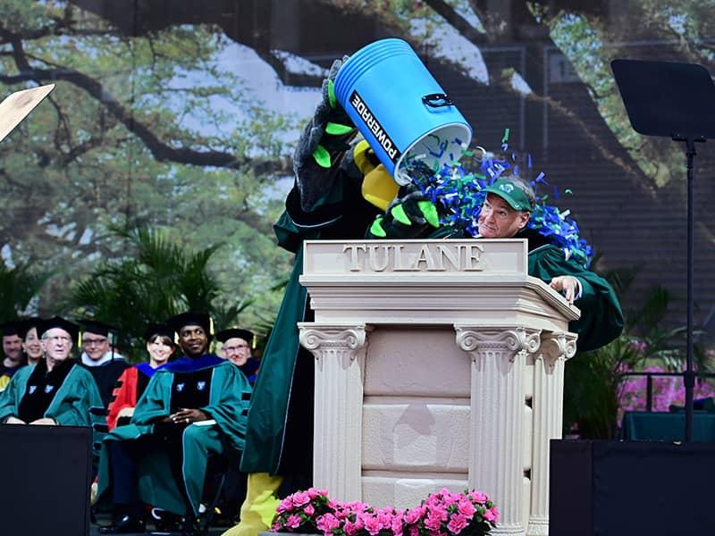 Riptide dumps a cooler of confetti on Fitts following his speech to graduates. (Photo by Cheryl Gerber) 