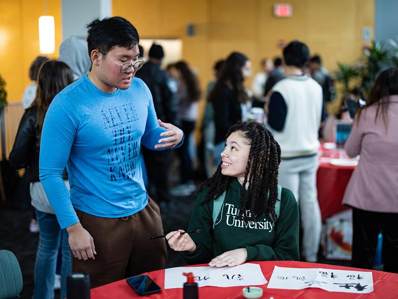 Yuncheng Chi (left), helps Katelyn Martin create Chinese characters.