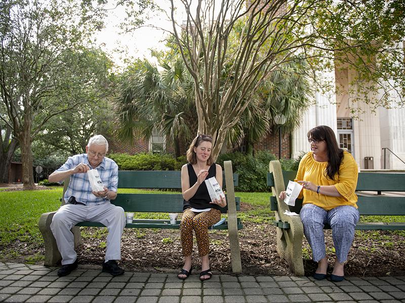 Walter Pons, Jessica Stephenson, and Jennifer French pause outside McAlister Auditorium for café au lait and beignets. All three are staff members in the chemistry department and were together Tuesday morning for the first time since COVID.