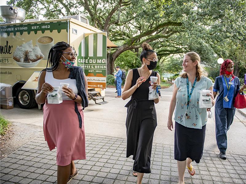 With breakfast in hand, Katie Valentine (left), Miracle Husband (center), and Megan St. Pierre (right) walk back to the Office of Undergraduate Education in the Freeman School of Business.