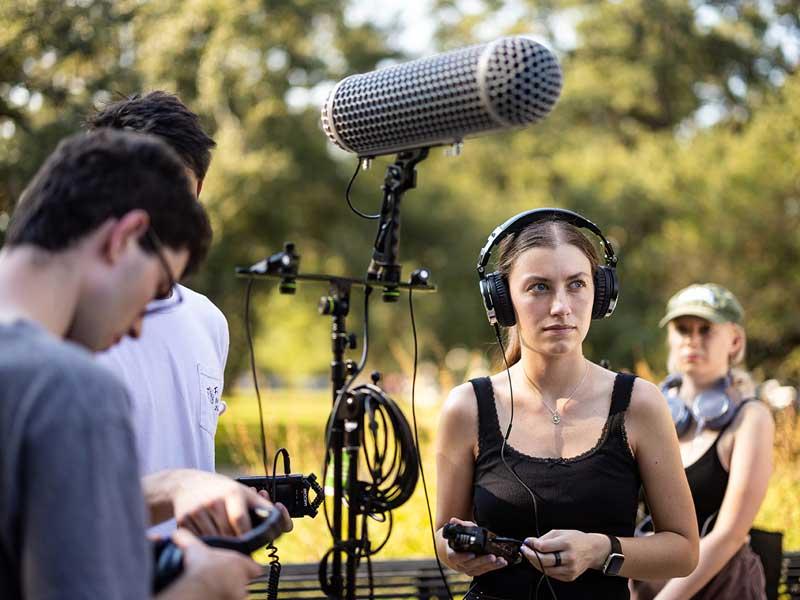 Student Abby Freedman listens to the sounds of the park through a shotgun mic.