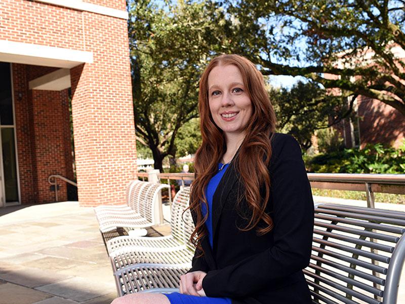 Amanda Heitz seated on bench on uptown campus