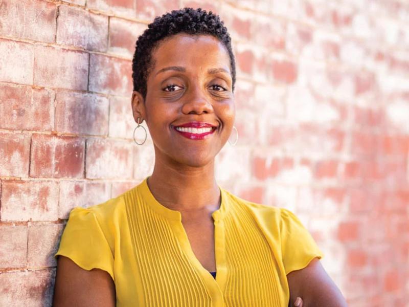 Adeola Ogunkeyede leaning against brick wall