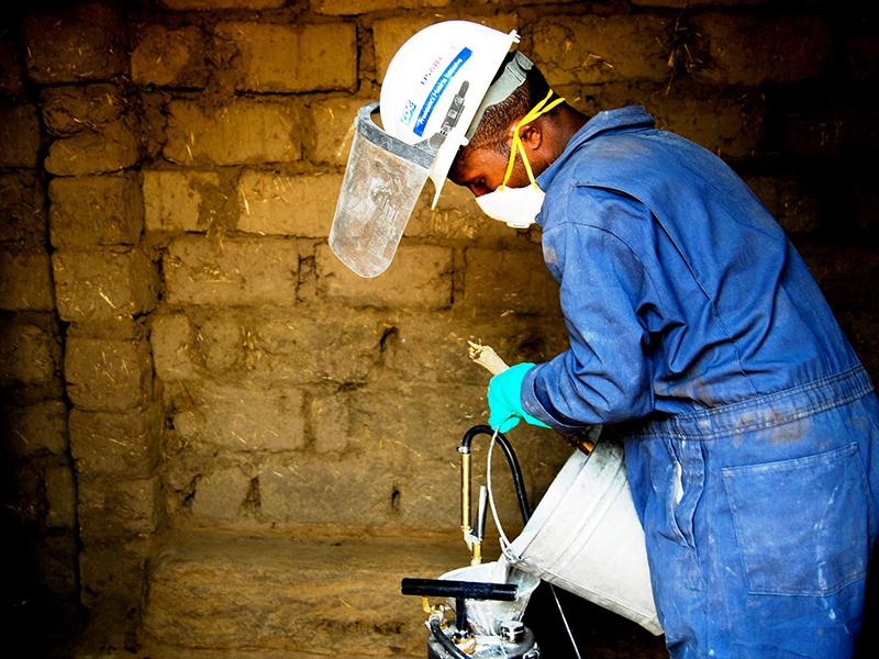 Man performs internal residual spraying to prevent malaria in the high risk region of Oromia