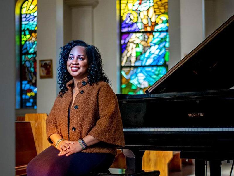 Professor Courtney Bryan seated at piano Professor Courtney Bryan seated at piano