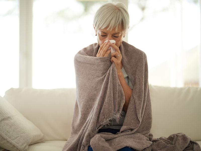 Woman sick with blanket over shoulders