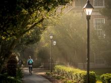 Sunlight streaks through early morning mist behind Newcomb Hall on the uptown campus.