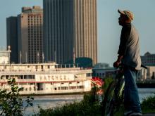 A man pauses on the Moonwalk along the Mississippi River levee near the French Quarter, as the Steamboat Natchez takes off for an evening cruise. 