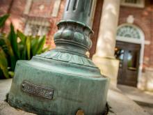 Decades of patina adorn the base of a light post outside of Dixon Hall on Tulane’s uptown campus.