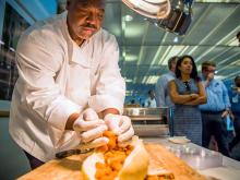 Michael Camper, a chef with Sodexo Dining Services, prepares a shrimp po-boy on a full loaf of Leidenheimer french bread for the event. 