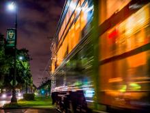 A glowing streetcar rumbles down St. Charles Avenue in front of Tulane’s uptown campus. 
