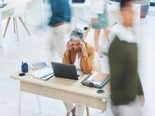 Woman sitting in office with head pain
