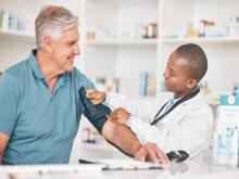 A pharmacist takes a man's blood pressure