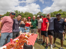 President Michael A. Fitts with students behind a table with crawfish