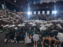 The audience at Convocation with white umbrellas