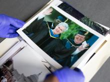 Archivist holds a printed photo of Newt Gingrich in academic gown