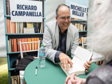 Smiling author Richard Campanella signs a book for a reader.