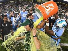 Green Wave players dump a cooler of sports drink over Coach Willie Fritz's head in celebration of the AAC game win. 