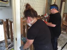 Cowen Institute staff members work on a flooded home.