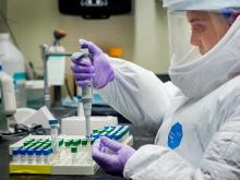 Lab worker with research tray at Tulane National Primate Research Center