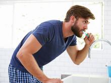 Man standing at sink, brushing his teeth Man standing at sink, brushing his teeth