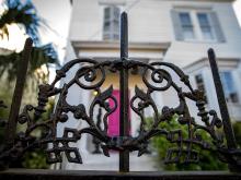 An ornate wrought iron gate protects a front yard garden in the Lower Garden District.