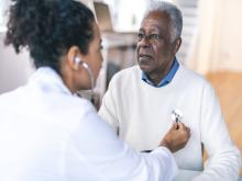 A doctor checks a man's heart beat