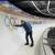Jared Firestone touches Olympic rings on a curved ice bobsled track.