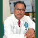 Portrait of a smiling doctor in a white lab coat and glasses.